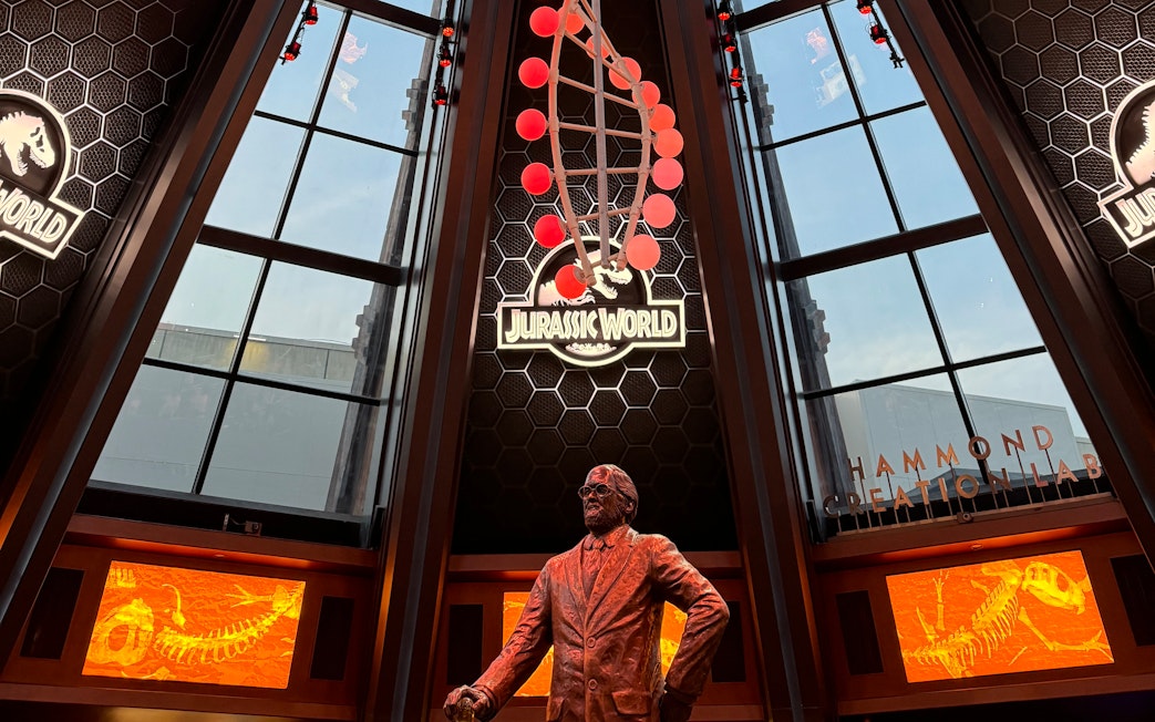 Interior of Jurassic World Adventure at Universal Studios Beijing featuring a statue and dinosaur displays.