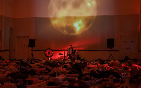 Participants lying on mats during The Sound Within immersive sound journey with Christian Dimarco in London.