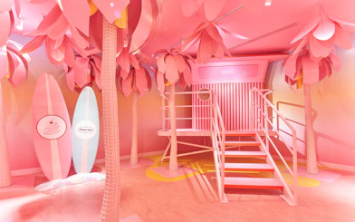 Museum of Ice Cream Singapore pink room with surfboards and palm trees.
