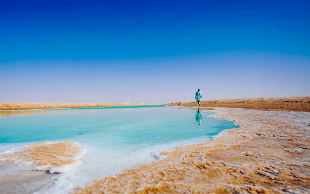 Person walking along a salt lake in Al Wathba, Abu Dhabi.