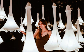 Visitor exploring illuminated art installation at IkonoMuseum.