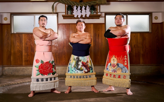 Sumo wrestlers in traditional attire at a Koto City sumo show.