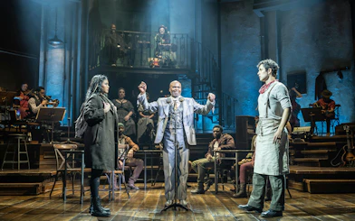 Stage performance of Hadestown in West End with actors and musicians on stage.