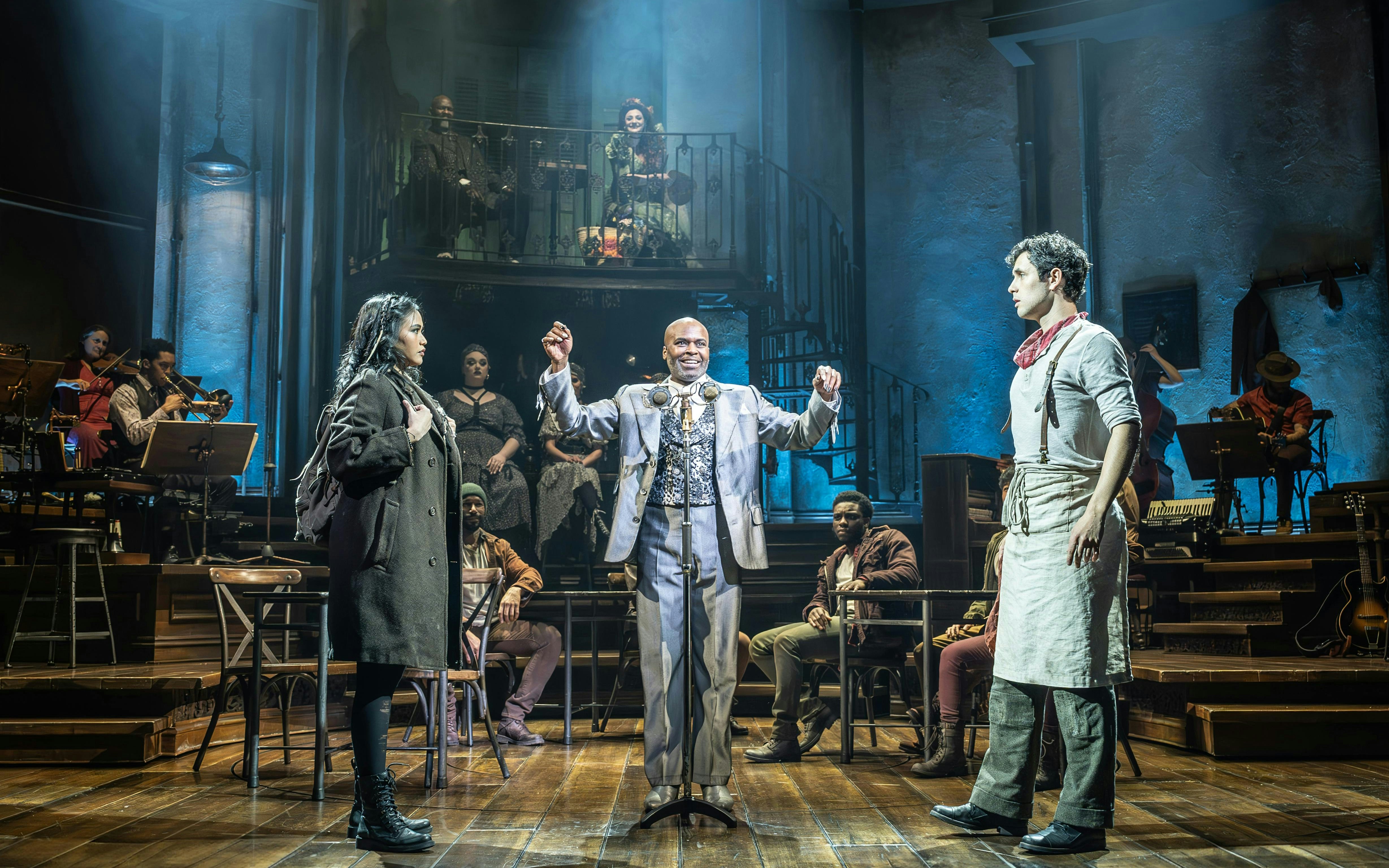 Stage performance of Hadestown in West End with actors and musicians on stage.