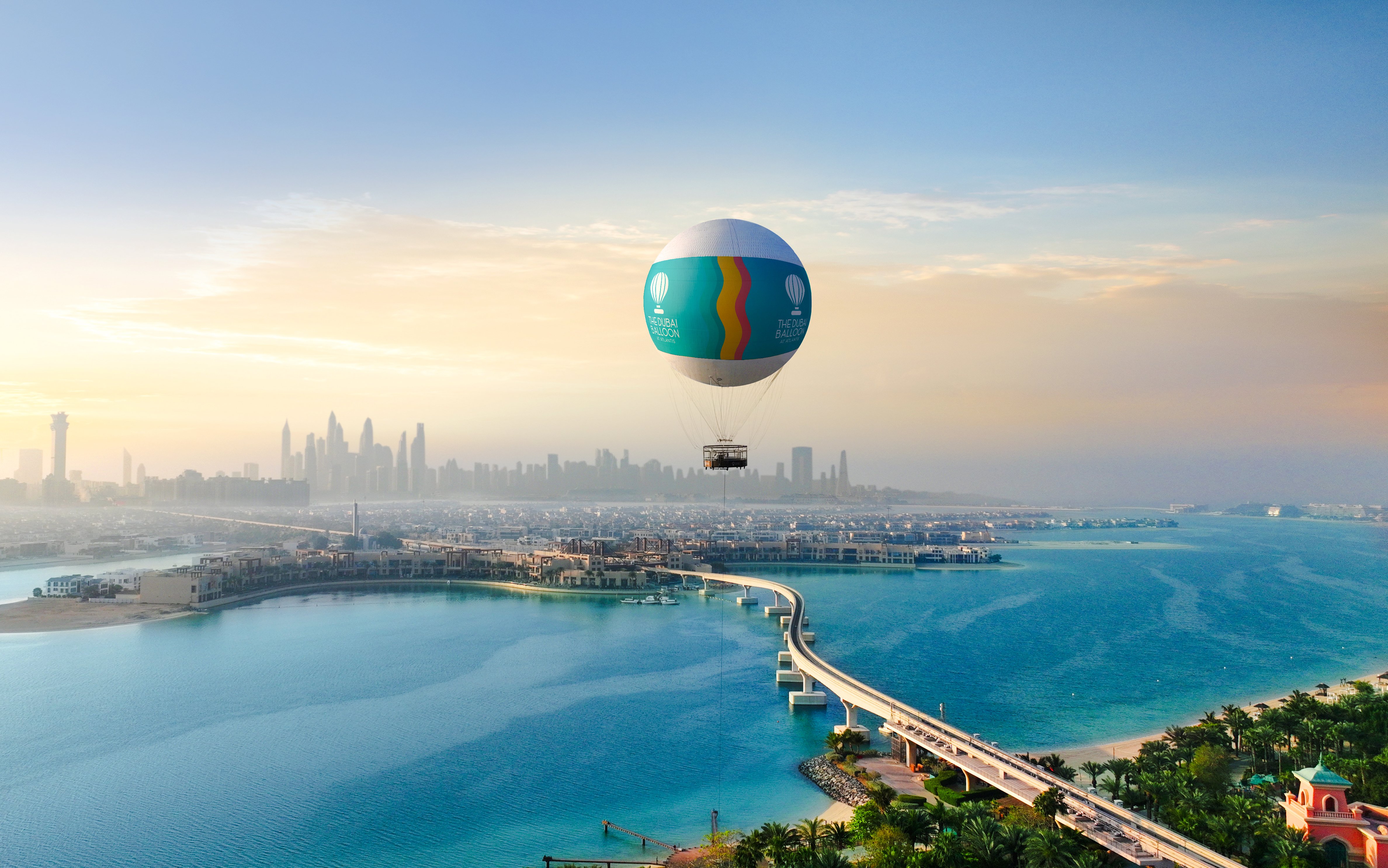Hot air balloon over Atlantis, Dubai with city skyline and Palm Jumeirah in view.