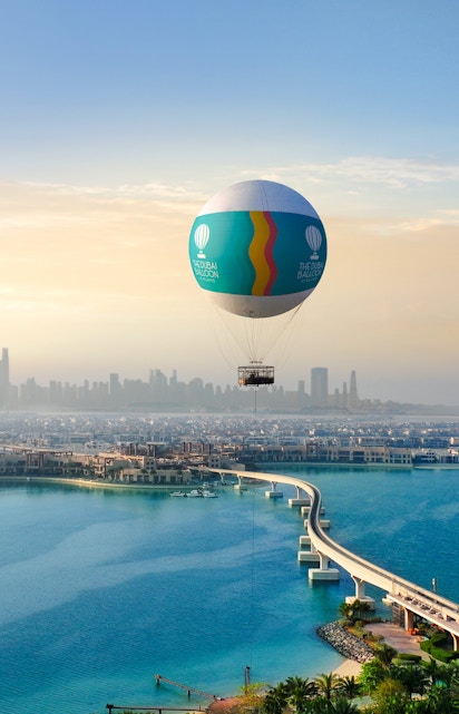 Hot air balloon over Atlantis, Dubai with city skyline and Palm Jumeirah in view.
