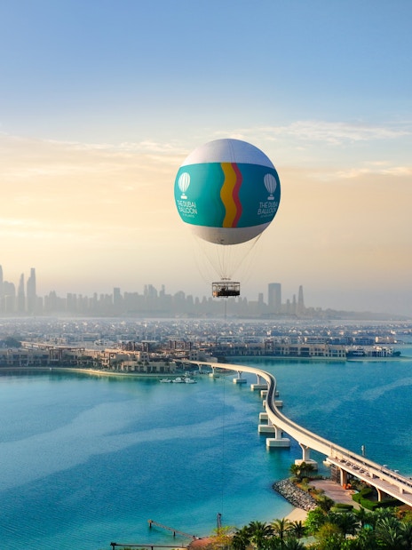 Hot air balloon over Atlantis, Dubai with city skyline and Palm Jumeirah in view.