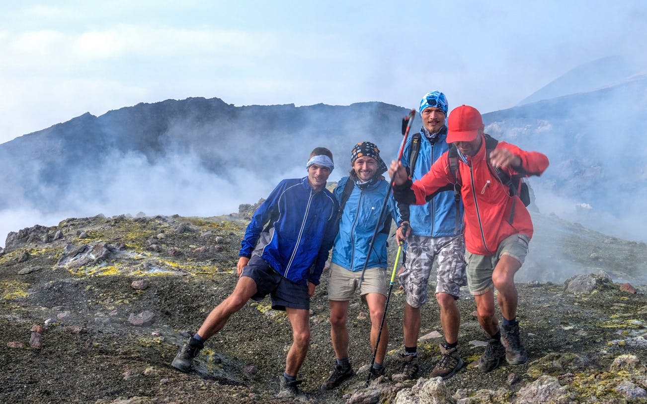 Group of hikers on a guided trek on the south side of Mount Etna, surrounded by volcanic terrain.