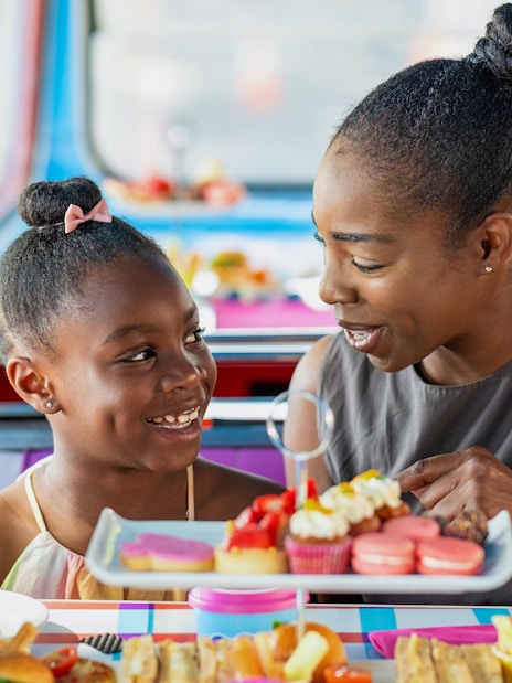 Guests enjoying treats on Peppa Pig themed bus tour for kids.
