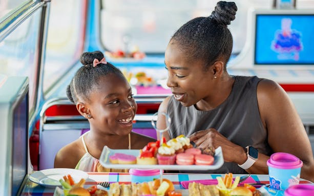 Guests enjoying treats on Peppa Pig themed bus tour for kids.