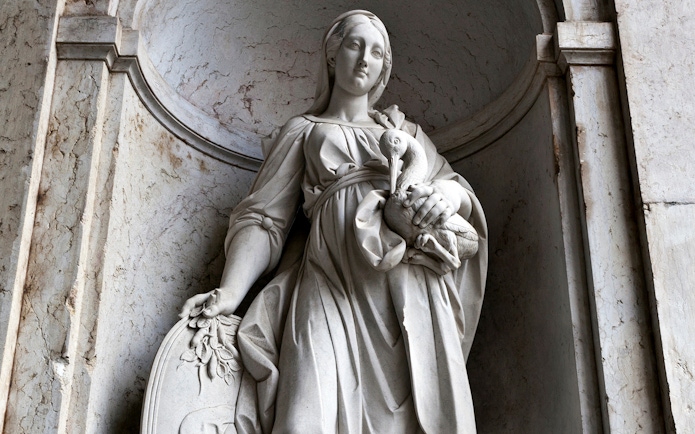 Statue of a woman holding a bird at the National Palace of Ajuda, Lisbon.