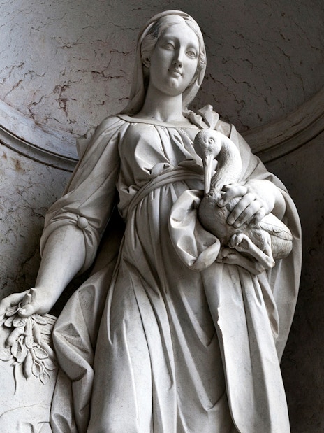 Statue of a woman holding a bird at the National Palace of Ajuda, Lisbon.