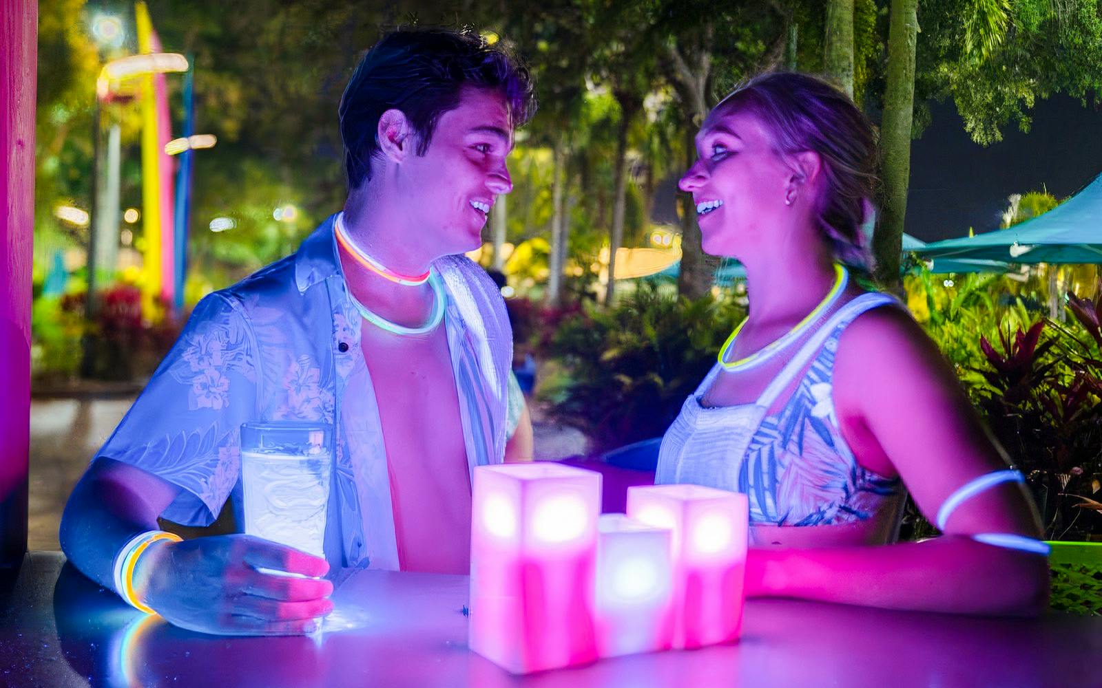 Couple enjoying AquaGlow event at Water Country USA with glowing accessories.