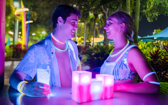 Couple enjoying AquaGlow event at Water Country USA with glowing accessories.