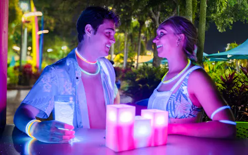 Couple enjoying AquaGlow event at Water Country USA with glowing accessories.