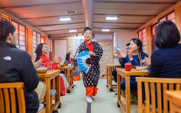 Guests enjoy a traditional Yakatabune hot pot dinner with a shamisen show in Japan.