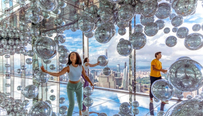 Visitors enjoying panoramic views from Summit One Vanderbilt observation deck in New York City.