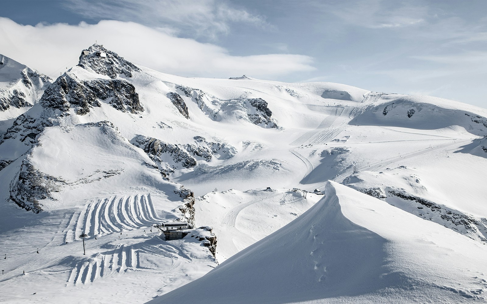 Matterhorn Glacier Paradise snowy landscape with ski tracks and mountain peaks.
