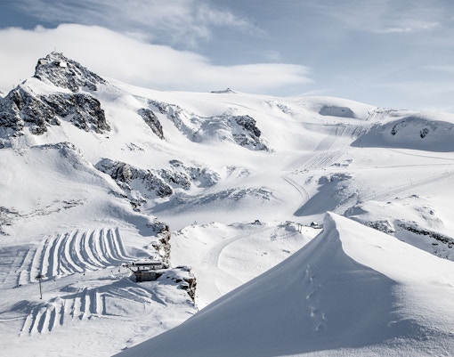 Matterhorn Glacier Paradise snowy landscape with ski tracks and mountain peaks.