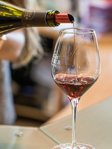 Pouring red wine into a glass during a wine tour in Avignon, France.