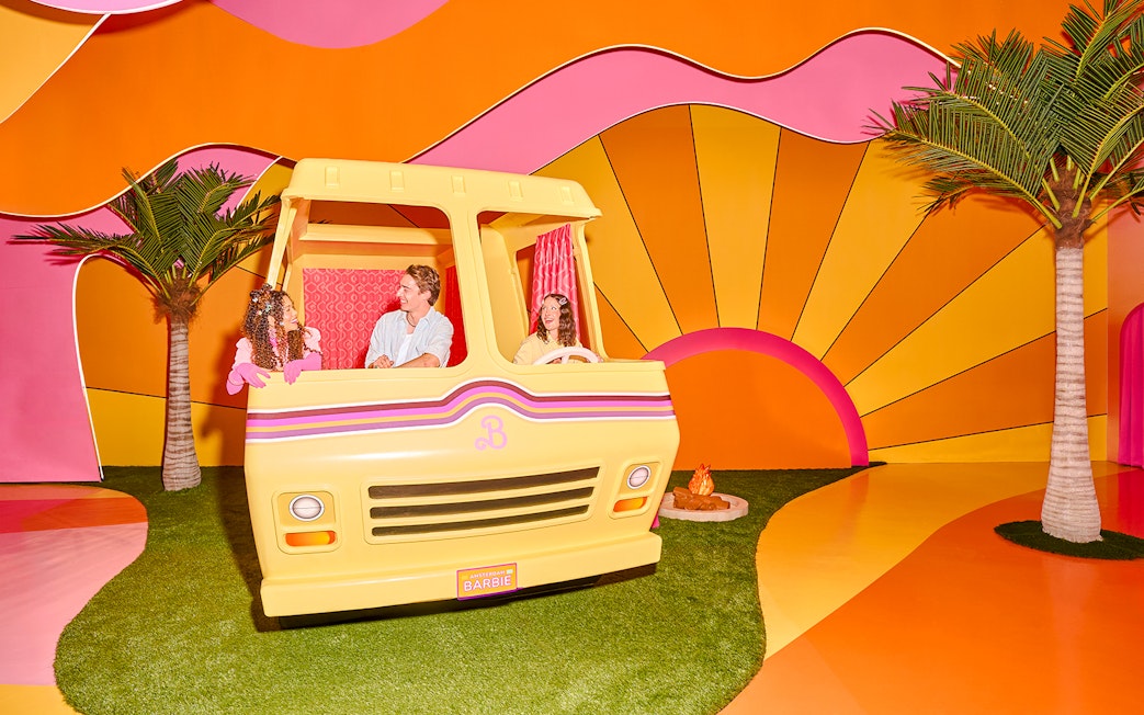Guests enjoying Barbie The Dream Experience in a colorful camper setup, Amsterdam.