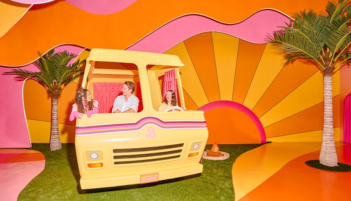 Guests enjoying Barbie The Dream Experience in a colorful camper setup, Amsterdam.