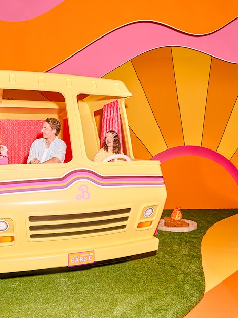 Guests enjoying Barbie The Dream Experience in a colorful camper setup, Amsterdam.