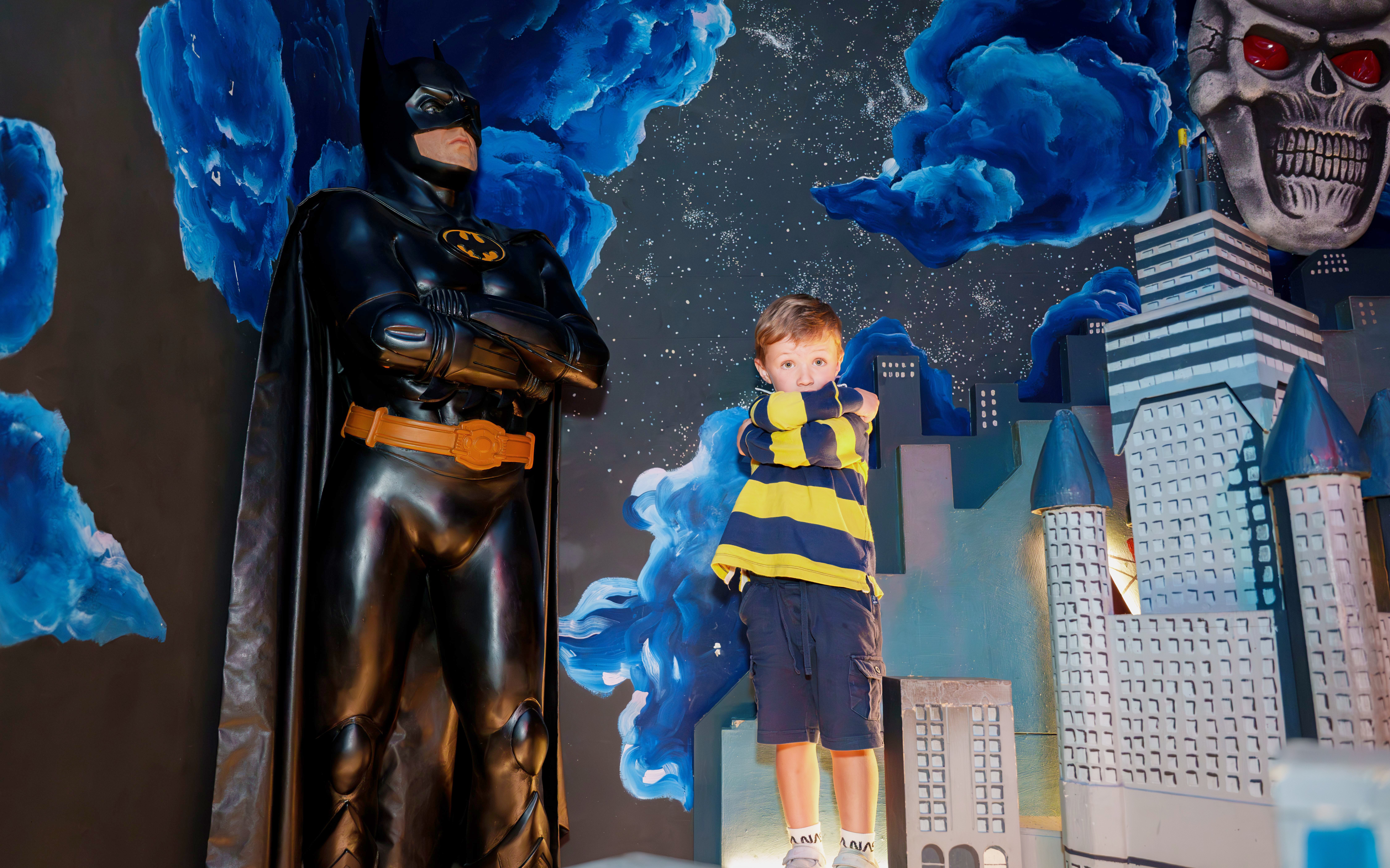Child posing with Batman figure at National Wax Museum.