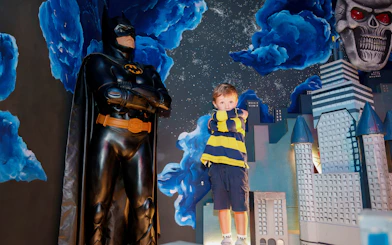 Child posing with Batman figure at National Wax Museum.