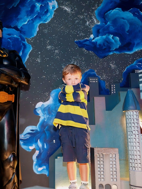 Child posing with Batman figure at National Wax Museum.