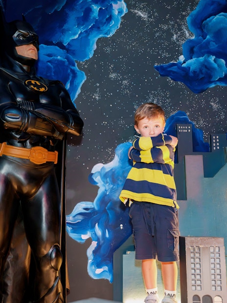Child posing with Batman figure at National Wax Museum.