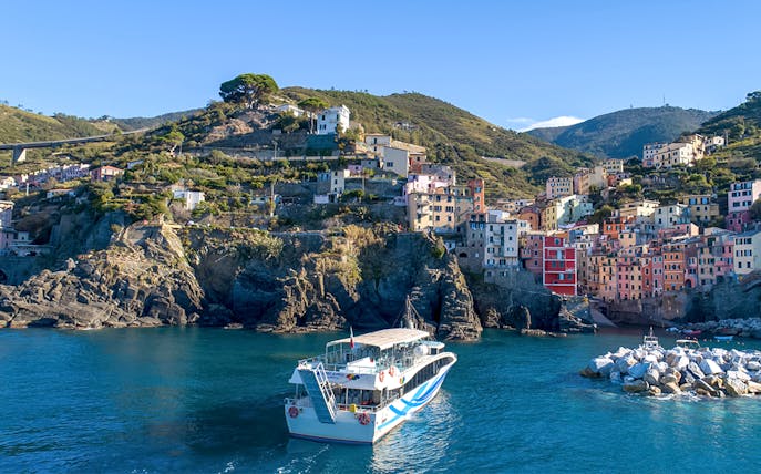 Ferry approaching colorful hillside village of Cinque Terre from La Spezia.