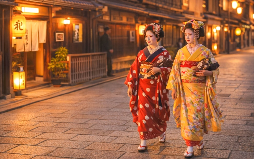 Geishas in traditional attire walking through Gion district, Kyoto.