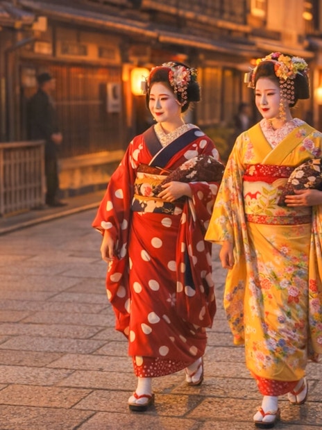 Geishas in traditional attire walking through Gion district, Kyoto.