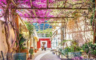 Pathway with blooming bougainvillea in Positano, Italy, leading to an art gallery.