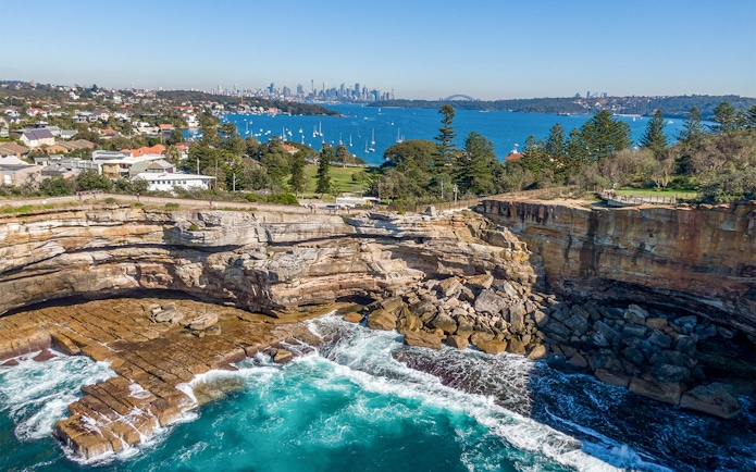 Cliffs and ocean view at Watsons Bay with Sydney skyline in the background.