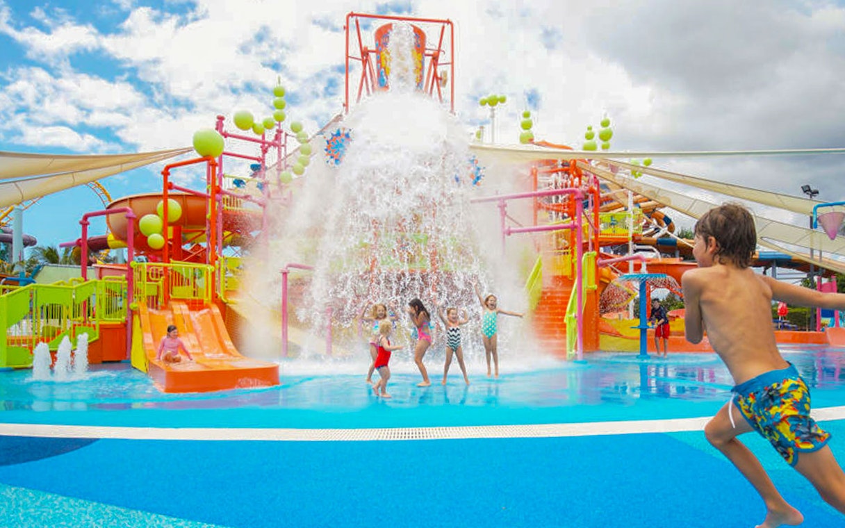 Children playing under water bucket at WhiteWater World, Gold Coast.