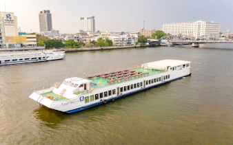 Riverside Faraya cruise boat on Chao Phraya River in Bangkok with cityscape background.