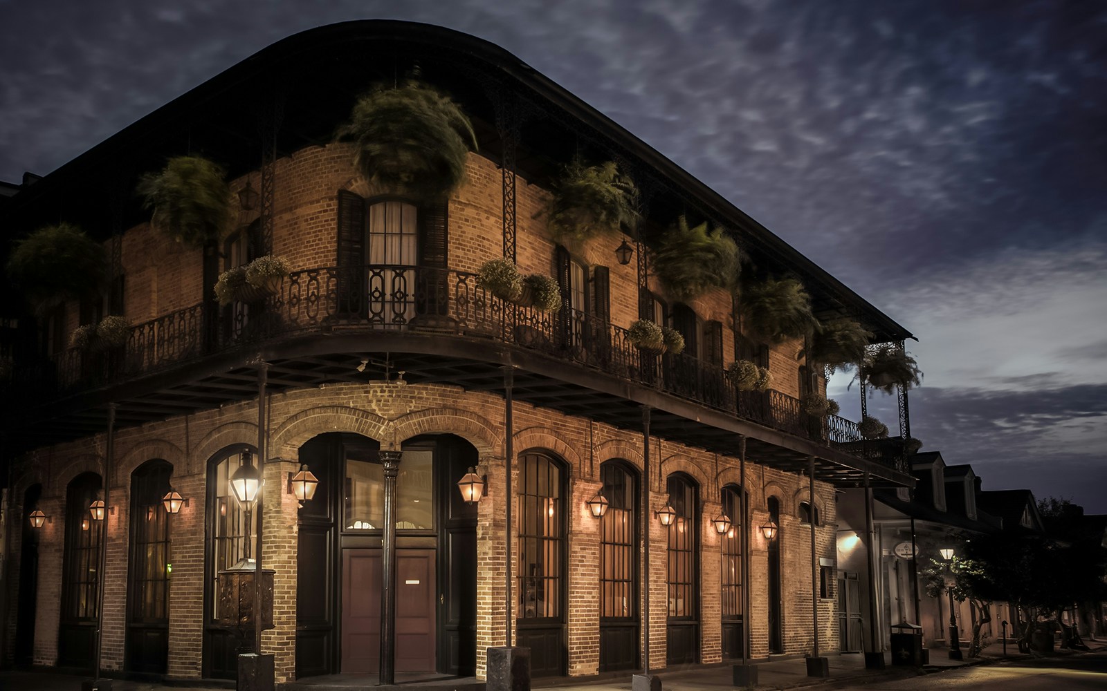 Historic building with wrought iron balconies at night in the French Quarter, New Orleans.