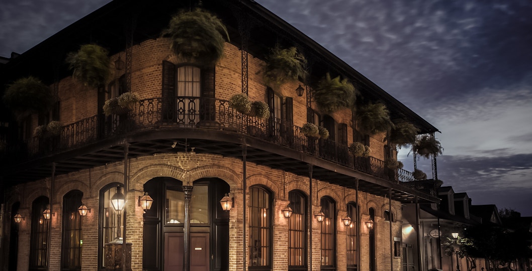 Historic building with wrought iron balconies at night in the French Quarter, New Orleans.