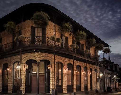 Historic building with wrought iron balconies at night in the French Quarter, New Orleans.