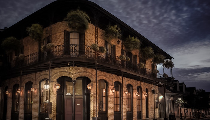 Historic building with wrought iron balconies at night in the French Quarter, New Orleans.