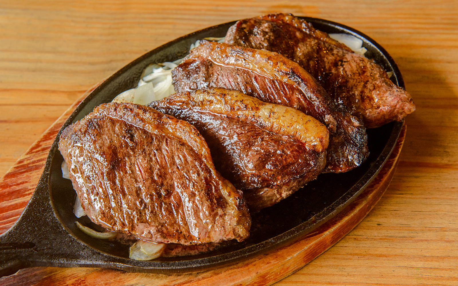 Brazilian picanha barbecue served on a sizzling platter.