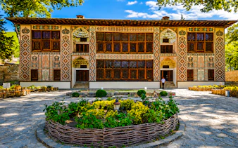 Khan's Palace in Sheki with intricate facade and garden, part of Baku to Sheki tour.