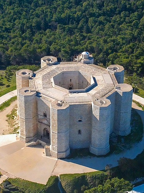 Aerial view of Castel del Monte surrounded by greenery in Andria, Puglia.