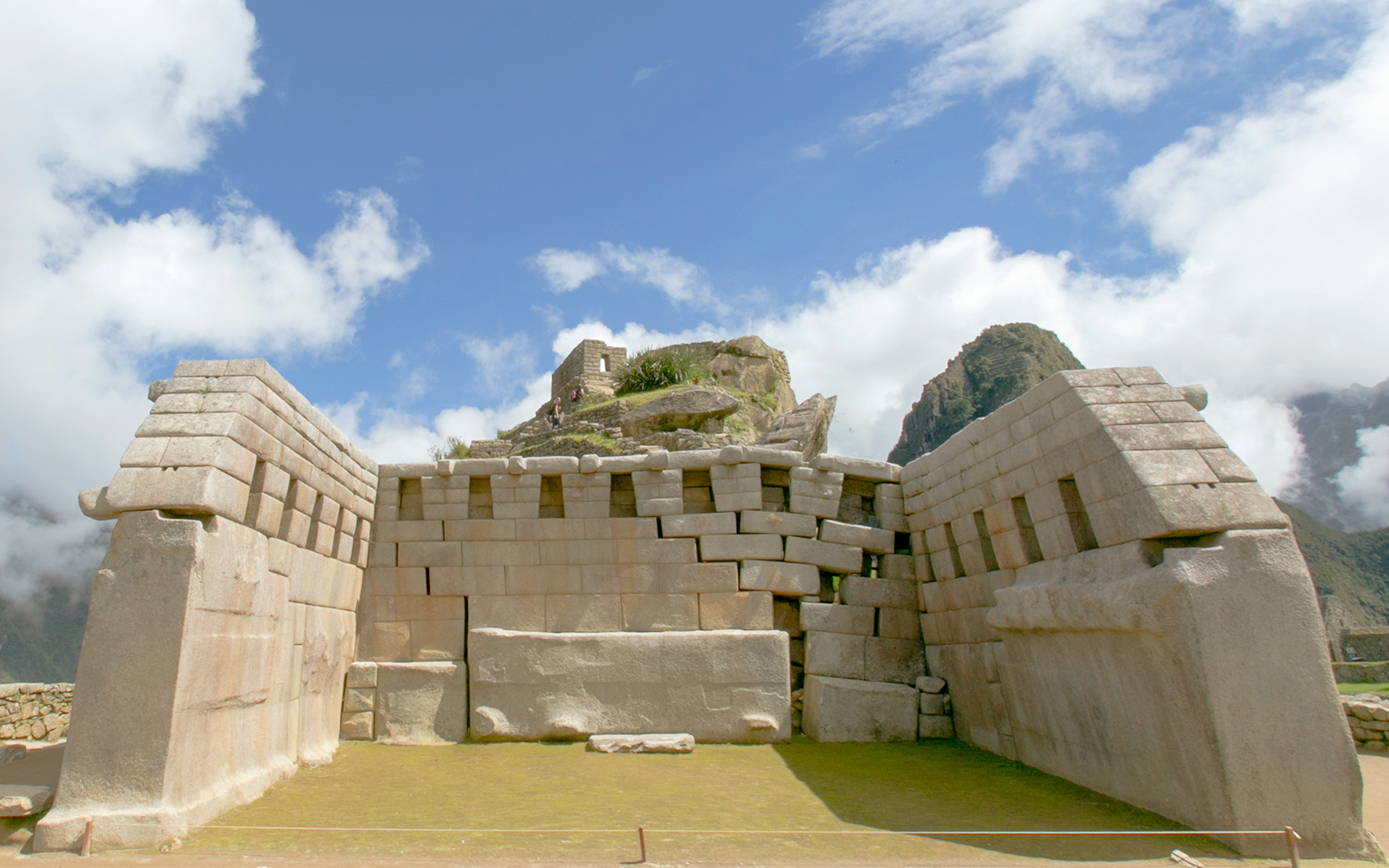 Ancient stone structure at Machu Picchu, Peru, with mountain backdrop.