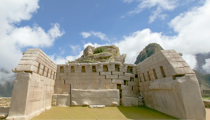 Ancient stone structure at Machu Picchu, Peru, with mountain backdrop.