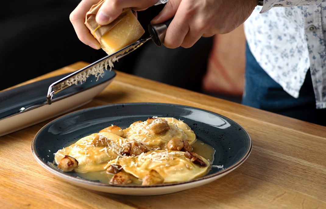 Outdoor dining setup with tables and chairs overlooking Valletta's skyline, Malta.