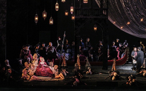 Opera scene from Les Contes d'Hoffmann with performers in elaborate costumes on stage.
