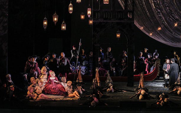 Opera scene from Les Contes d'Hoffmann with performers in elaborate costumes on stage.